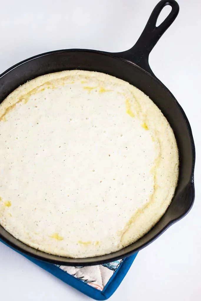 A cast iron skillet with batter in it