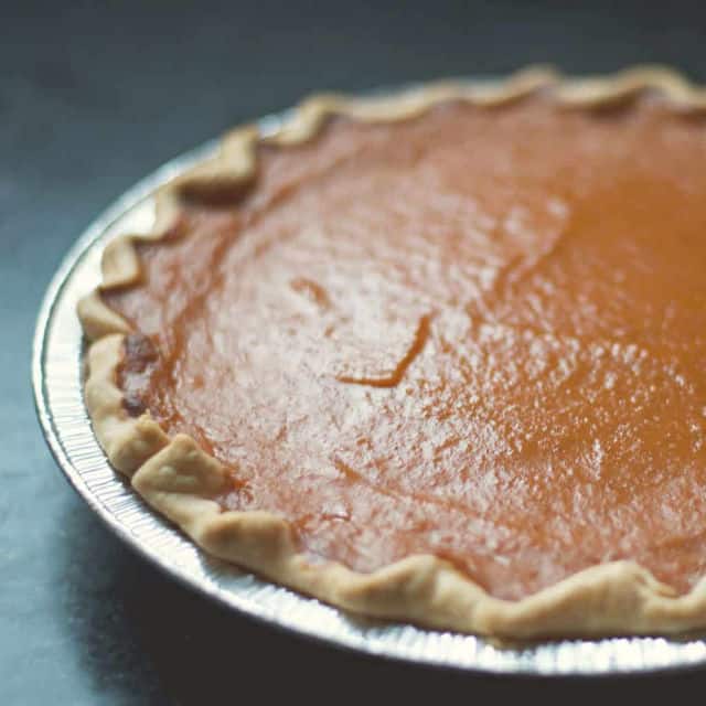 pumpkin pie from the side in an aluminum pie pan