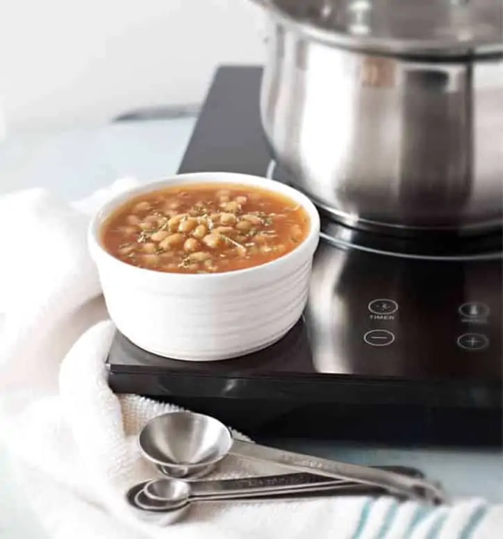 A bowl of baked beans sitting on a cooktop for How to Cook Canned Baked Beans