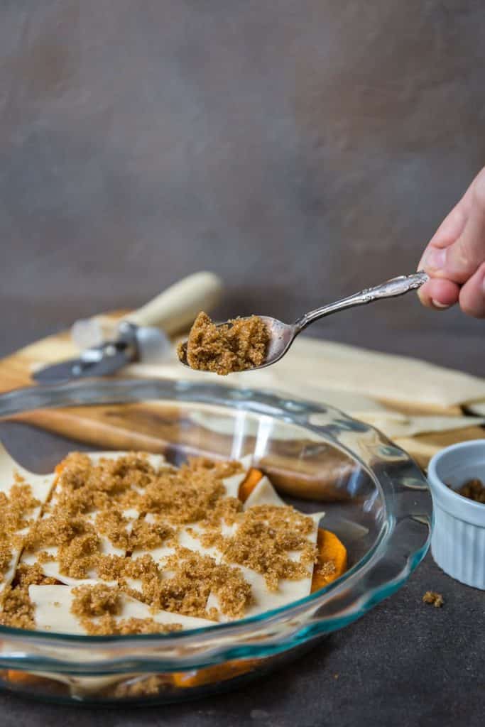 adding more ingredients to sweet potato cobbler