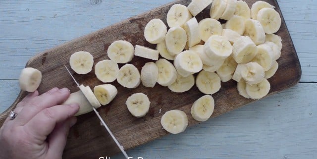 Bananas being cut into disks on cutting board