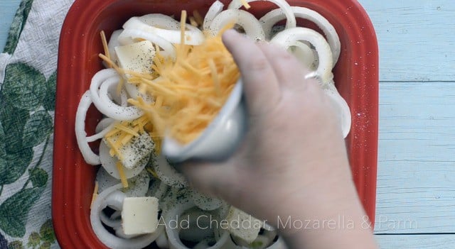 Red dish with vidalia onion slices and cheese being sprinkled on top