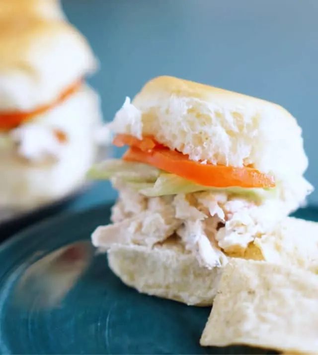 A Hawaiian roll with mix, tomato and lettuce.