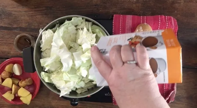 Adding the stock to the stockpot for cooked cabbage