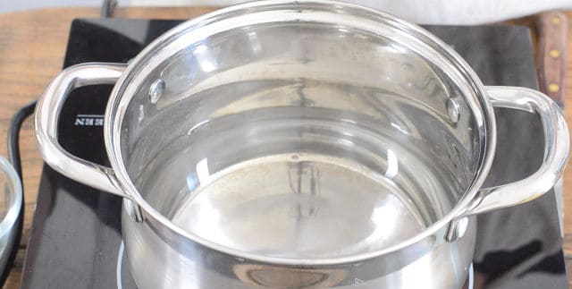 A pot of water heating on the stovetop