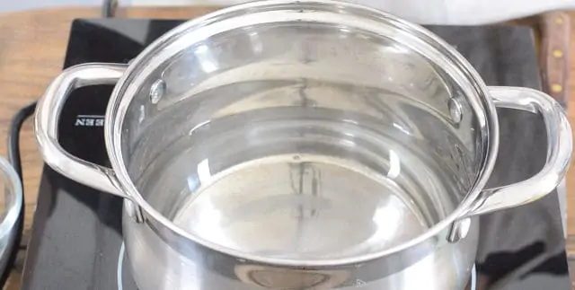 A pot of water heating on the stovetop