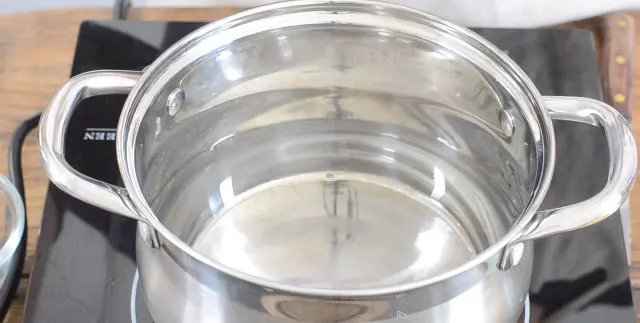A pot of water heating on the stovetop