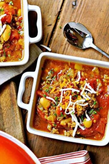 Two square white bowls of pinto bean soup recipe with a spoon