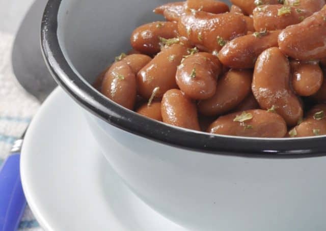 A close up of some kidney beans in a blue bowl with a black rim