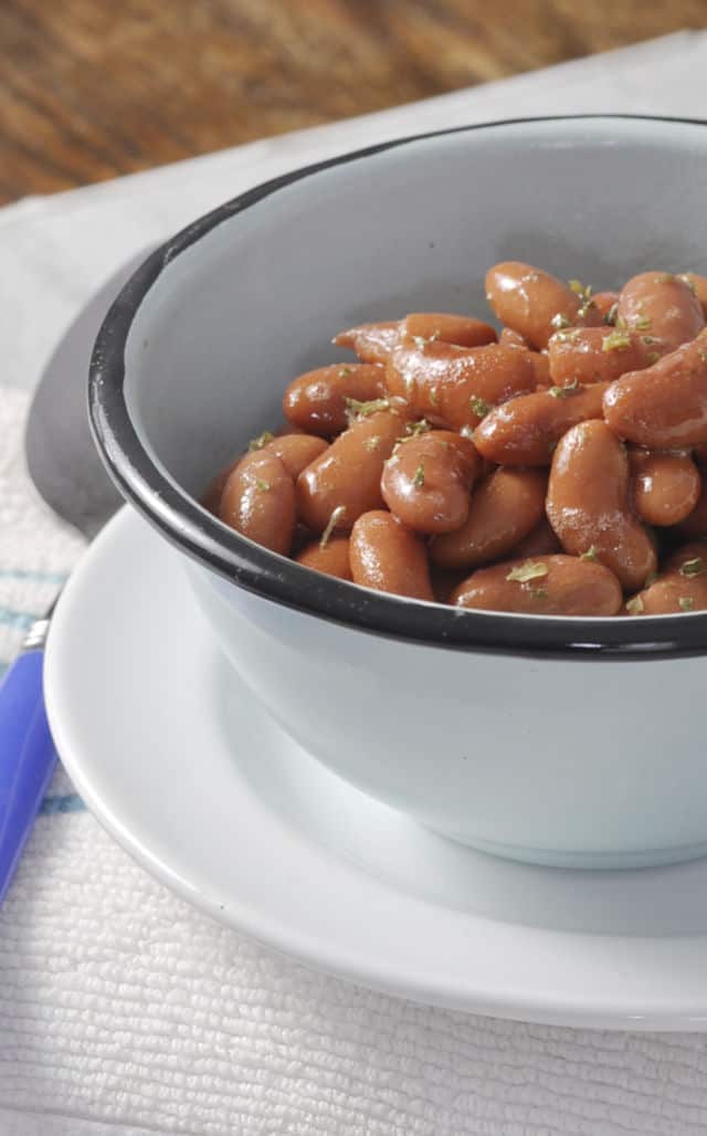 A close up of some kidney beans in a blue bowl with a black rim