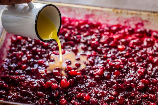 Orange juice being poured onto the cranberries