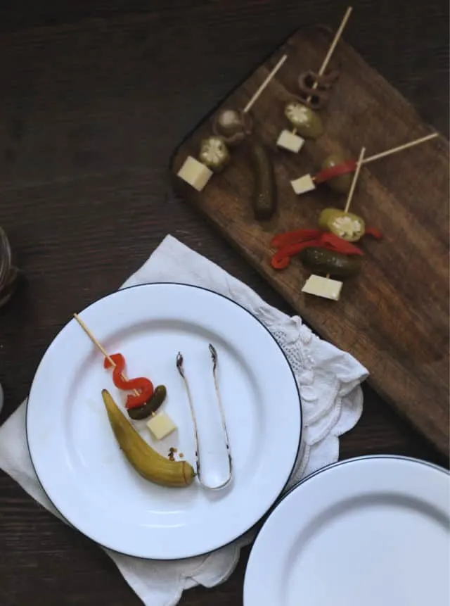 A plate of a pickled okra appetizer with others on a cutting board