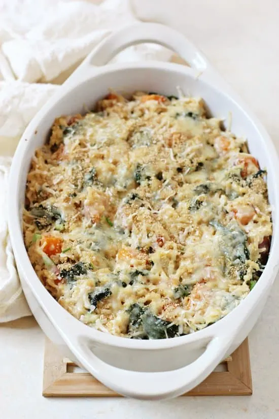 a white casserole dish holding the casserole with melted cheese on top