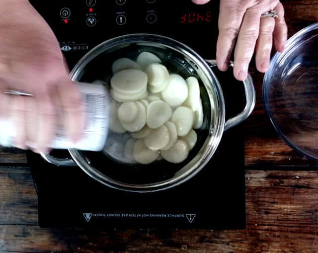 Adding the canned potatoes to the saucepan