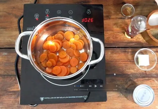 A saucepan full of carrots on the stovetop