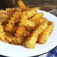 Crispy golden fries on a white plate for how to cook frozen fries