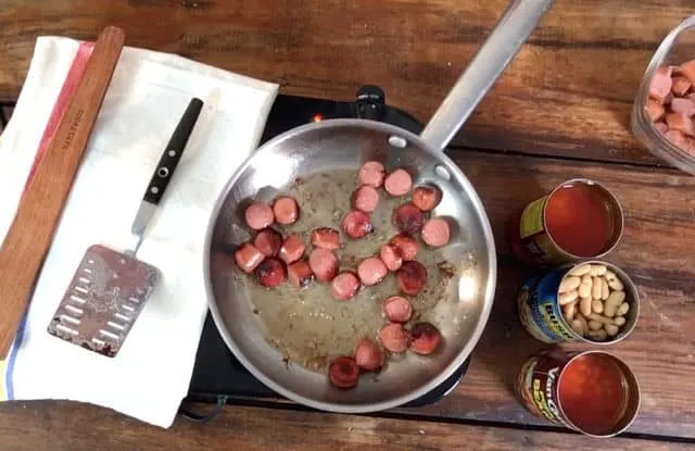 A pan of hot dogs browning