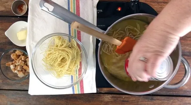 photo of adding canned chicken noodle soup to the sauce pan