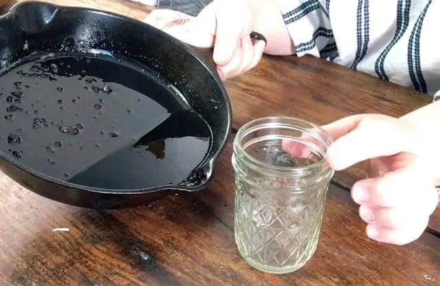 an empty jelly jar and black cast iron skillet