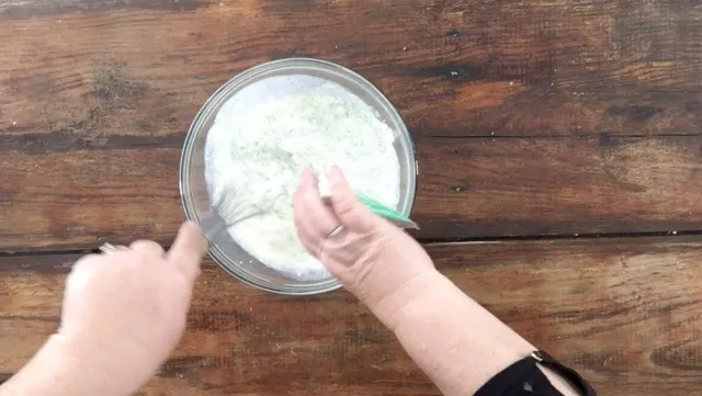 A photo of adding a ranch packet to the milk and mayonnaise mixture in a glass bowl