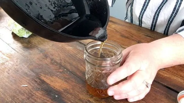 pouring the bacon grease into the jelly jar