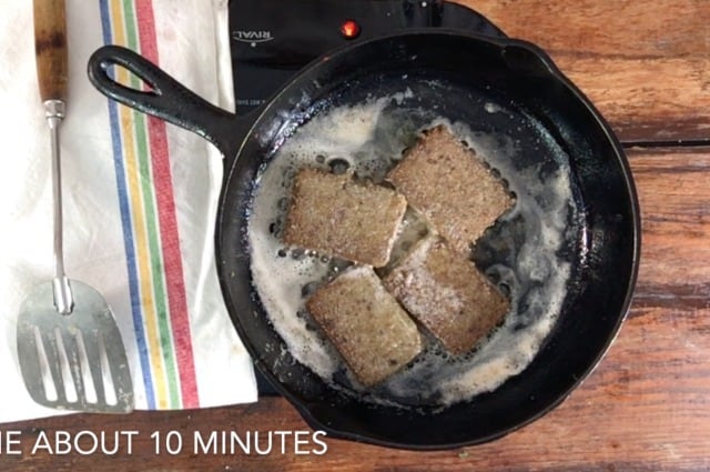 four slices of livermush frying in the pan