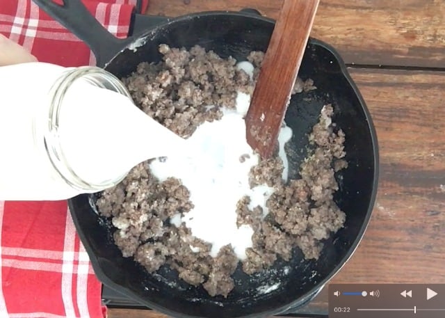 a photo of a quart jar of milk being poured into the skillet filled with ground beef, seasoning and other ingredients.