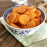 Blue bowl of carrots on green napkin with fork