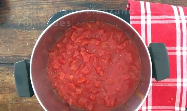 Saucepan with crushed tomatoes in it, red napkin