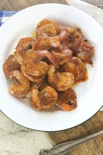 white plate with red shrimp, blue napkin in background