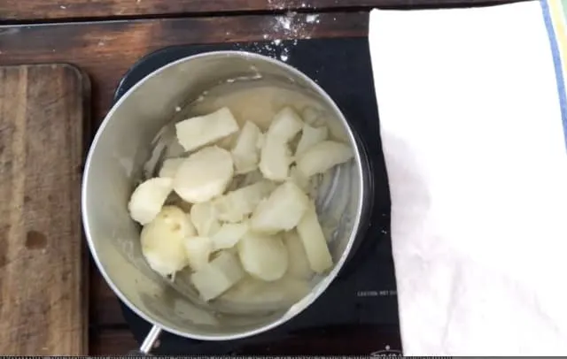 Potatoes and roux in a sauce pan with towel