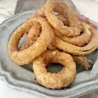 grey plate on a cutting board with crispy onion rings