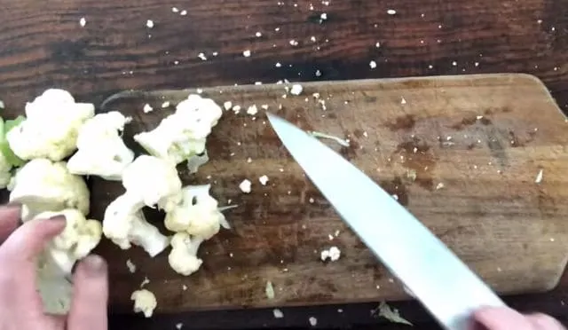 knife on cutting board with cauliflower
