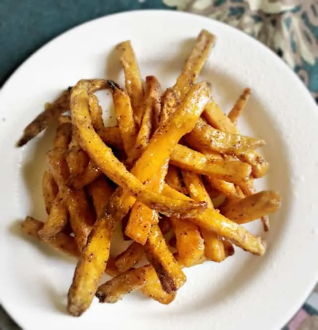 white plate of fries from overhead with blue tablecloth in background