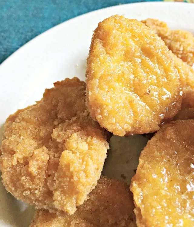 Close up of chicken nugget surface sitting on white plate