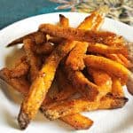white plate on blue table cloth with sweet potato fries