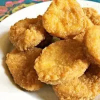 White plate holding a pile of chicken nuggets