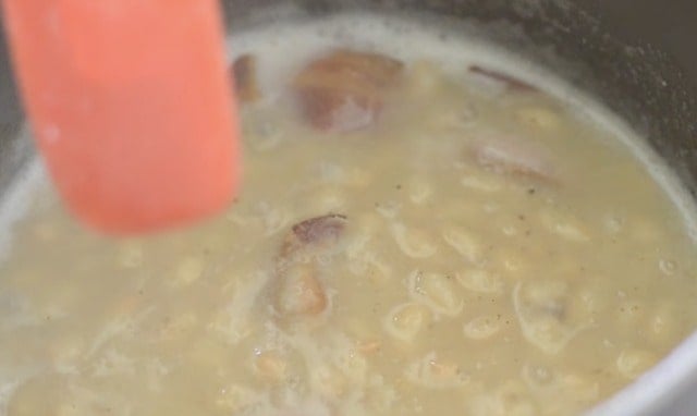 Stiring the sauce pan with red spatula