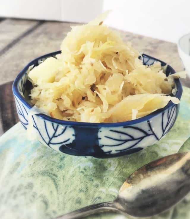 a blue bowl of german sauerkraut on a green napkin