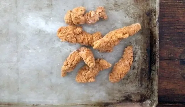 frozen chicken strips on a baking sheet