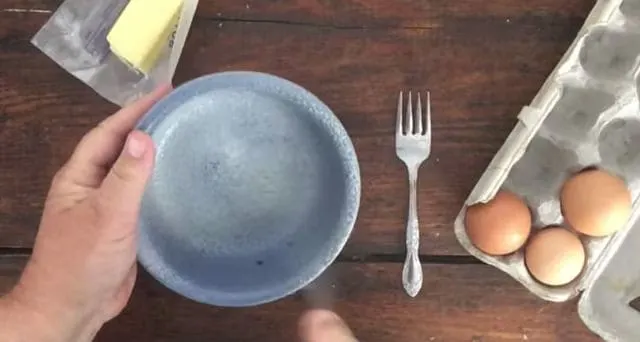 hand spraying blue bowl with spray