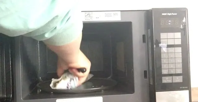 hand removing asparagus from microwave