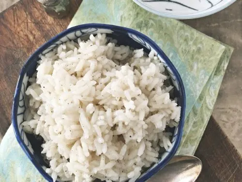 overhead shot of a small blue bowl of rice on a green napkin