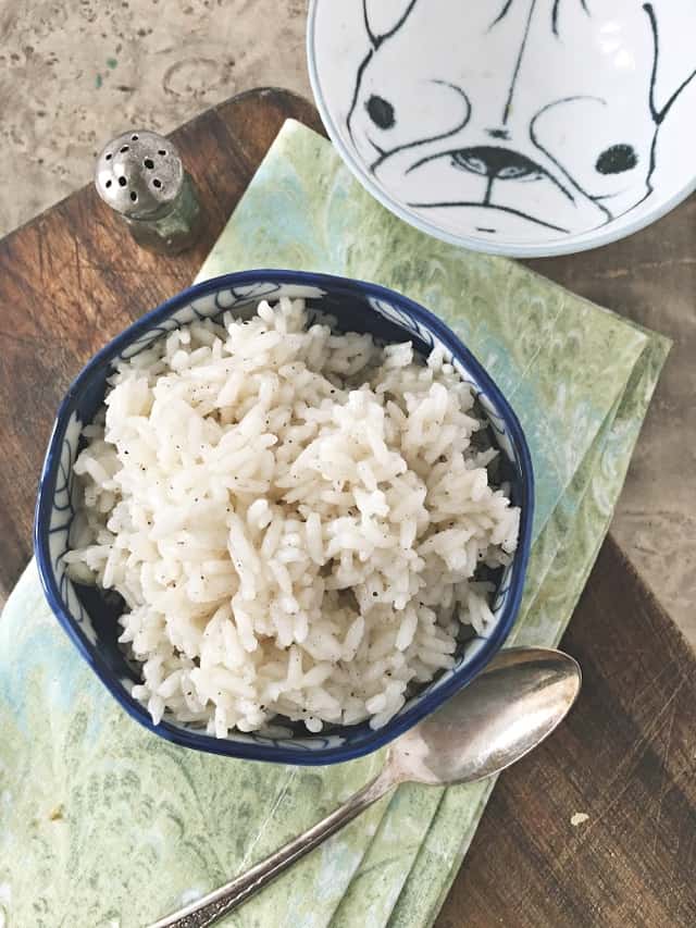 overhead shot of a small blue bowl of rice on a green napkin