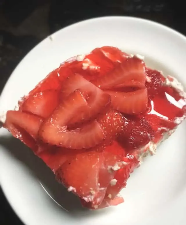 A single slice of pretzel salad with strawberries on top.