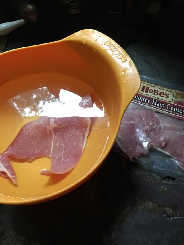 slice of country ham soaking in water