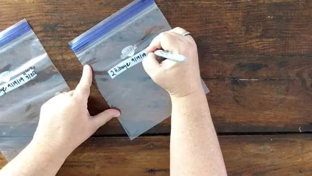hand writing on a plastic bag with a sharpie marker
