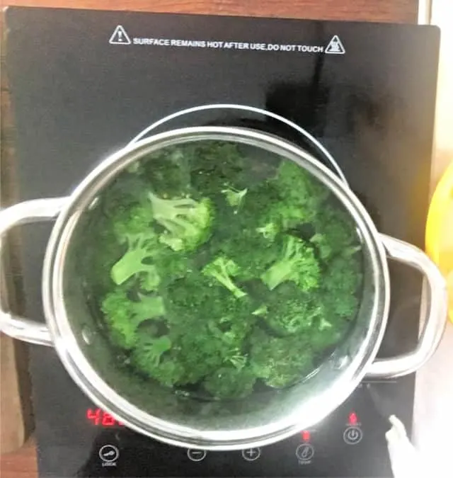 broccoli in a stock pot boiling on stove eye