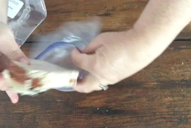 hands putting lunch meat into freezer bag
