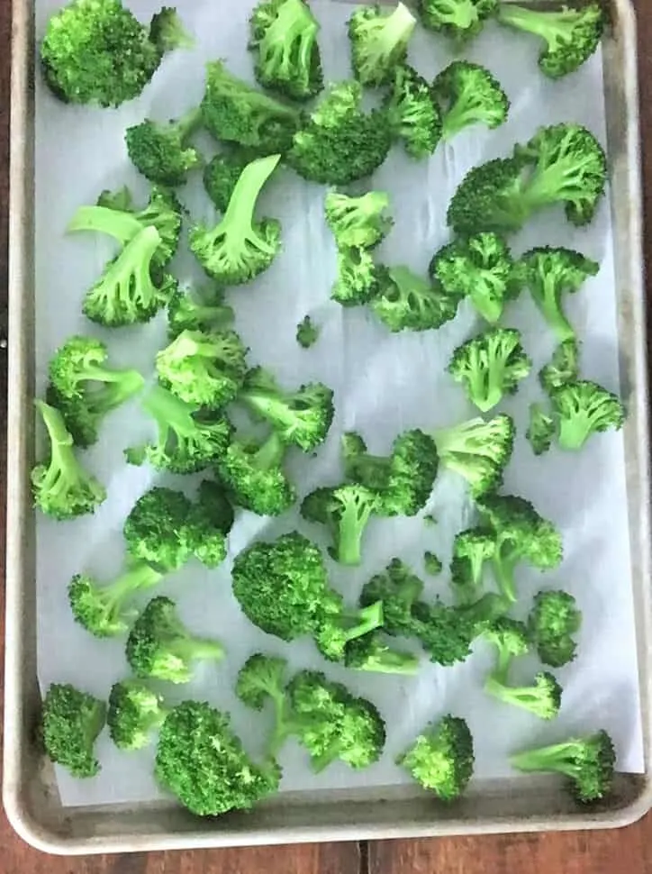broccoli layed out on parchment paper on baking sheet
